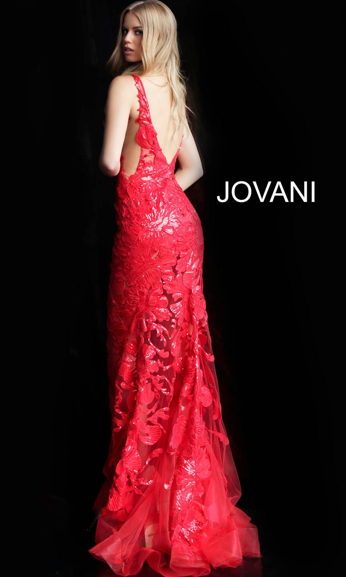 A woman in a sleeveless, floor-length Jovani Embroidered Long Prom Dress with Sequins and floral details, featuring a low back, stands against a black background.